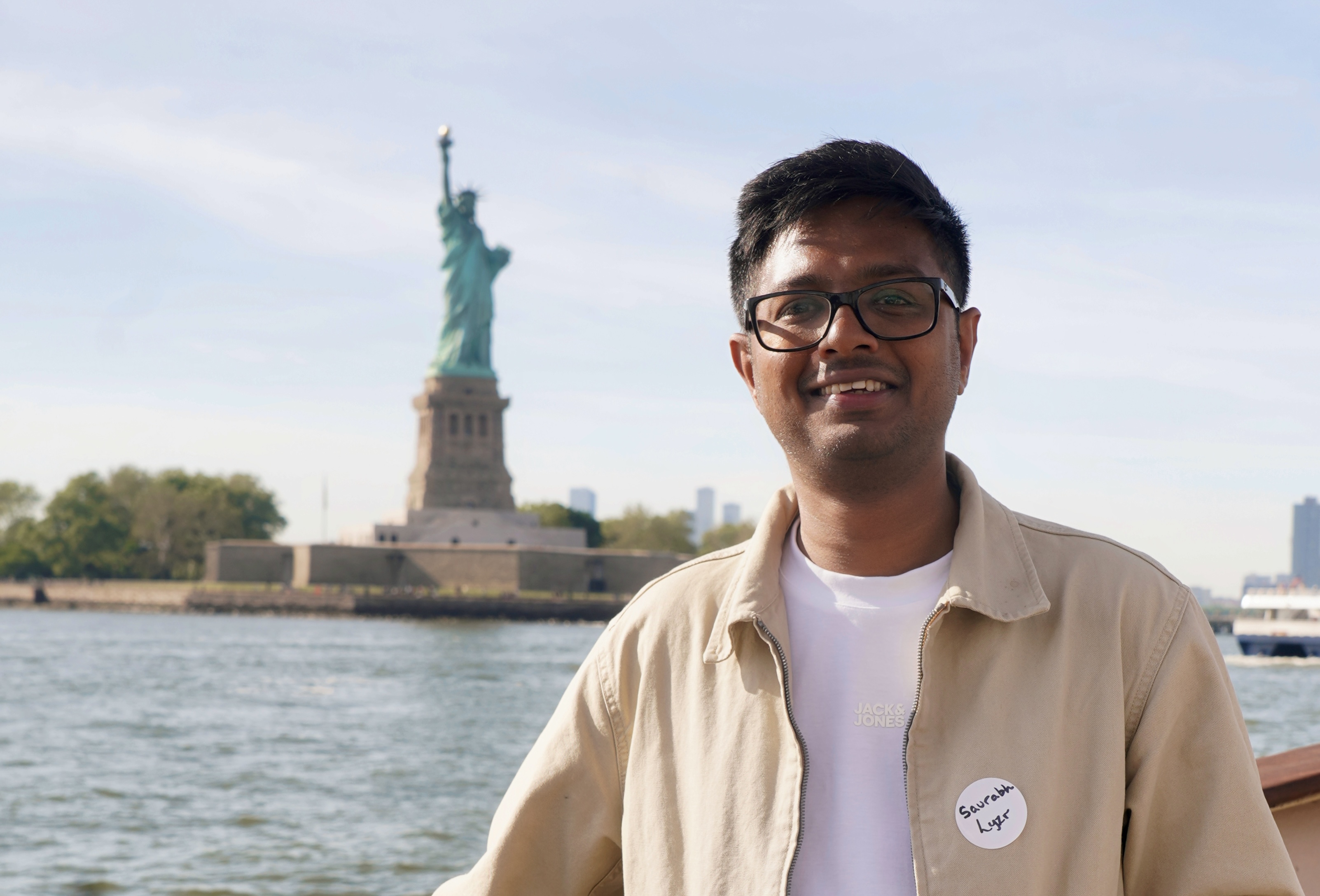 Saurabh Jain in New York with the Statue of Liberty in the background